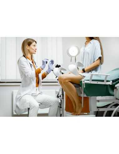 Gynécologue préparant une procédure d'examen pour une femme enceinte assise sur une chaise gynécologique du bureau